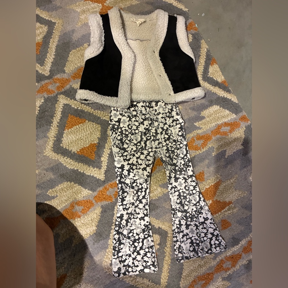Black and white floral flare pants and black vest with fur